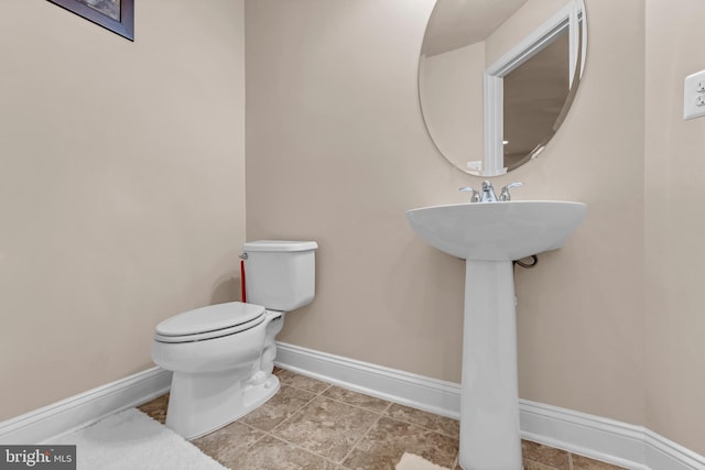 bathroom with toilet and baseboards