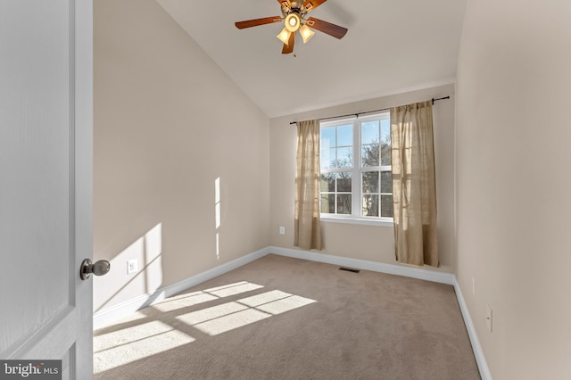 carpeted empty room with lofted ceiling, baseboards, visible vents, and ceiling fan