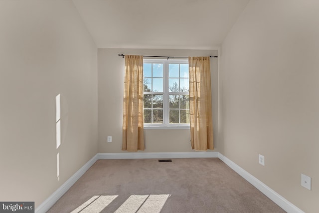 unfurnished room featuring vaulted ceiling, carpet floors, visible vents, and baseboards