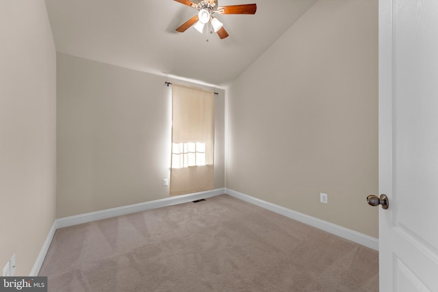 spare room with carpet, visible vents, a ceiling fan, vaulted ceiling, and baseboards