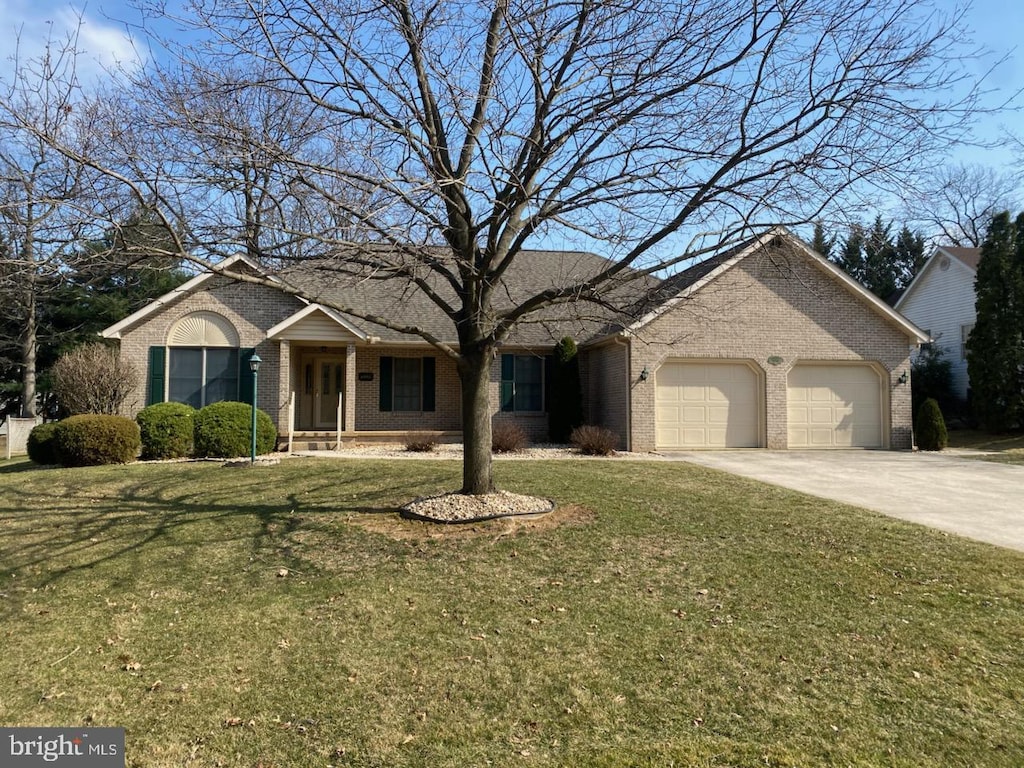 ranch-style home featuring a front yard, brick siding, concrete driveway, and an attached garage