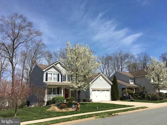 traditional-style house with a front yard, covered porch, an attached garage, and concrete driveway