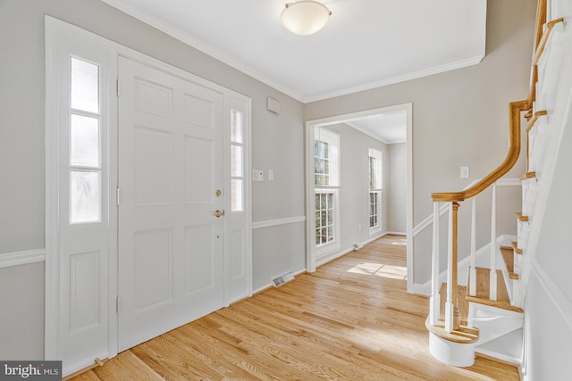 entryway featuring crown molding, stairway, wood finished floors, and visible vents