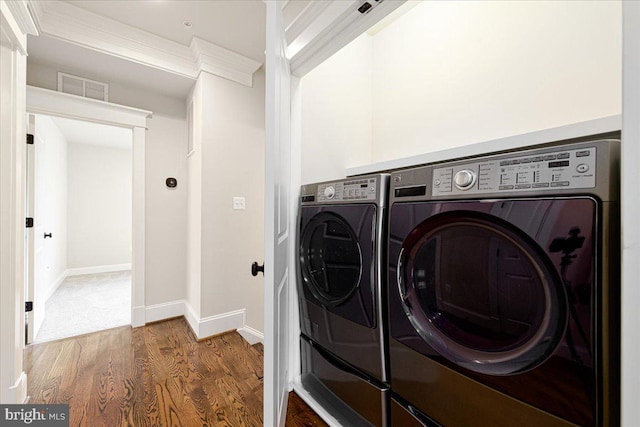 clothes washing area featuring wood finished floors, baseboards, visible vents, laundry area, and independent washer and dryer