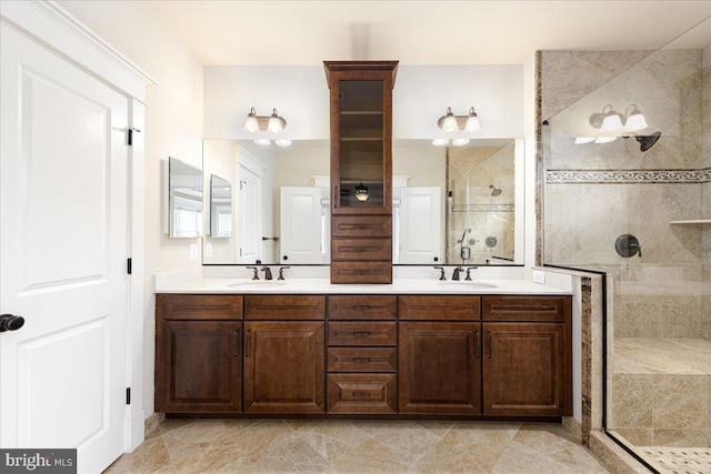 full bathroom featuring a shower stall, double vanity, and a sink