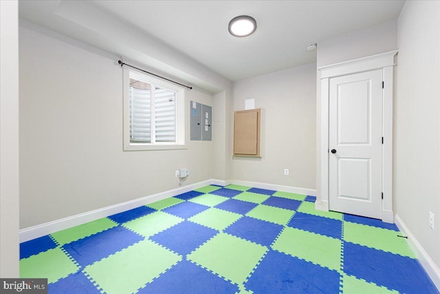 spare room featuring tile patterned floors, electric panel, and baseboards