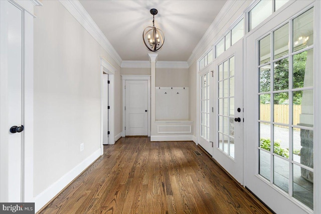 doorway featuring visible vents, crown molding, baseboards, an inviting chandelier, and dark wood-style flooring