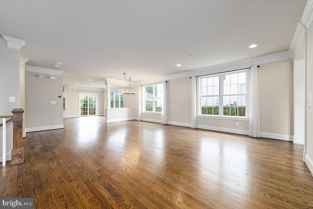 unfurnished living room featuring crown molding, baseboards, and wood finished floors