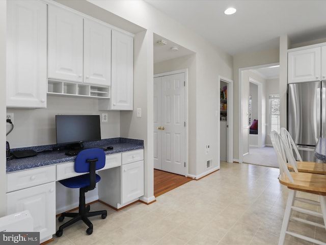 office area with built in desk, recessed lighting, visible vents, and baseboards