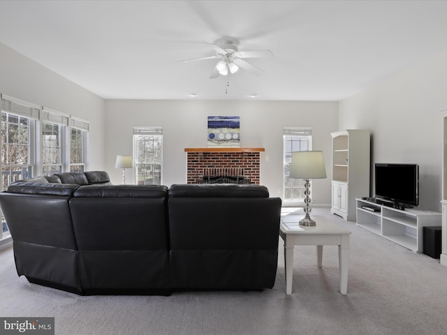 carpeted living room featuring a ceiling fan and a fireplace