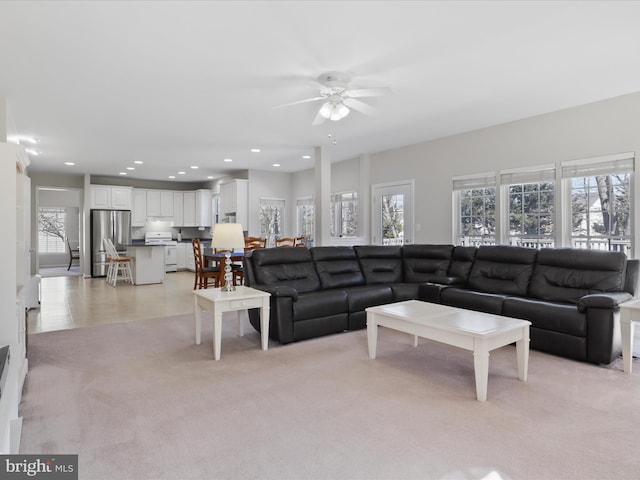 living area featuring recessed lighting, light colored carpet, and a wealth of natural light