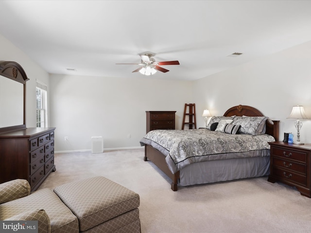 bedroom with a ceiling fan, light colored carpet, visible vents, and baseboards