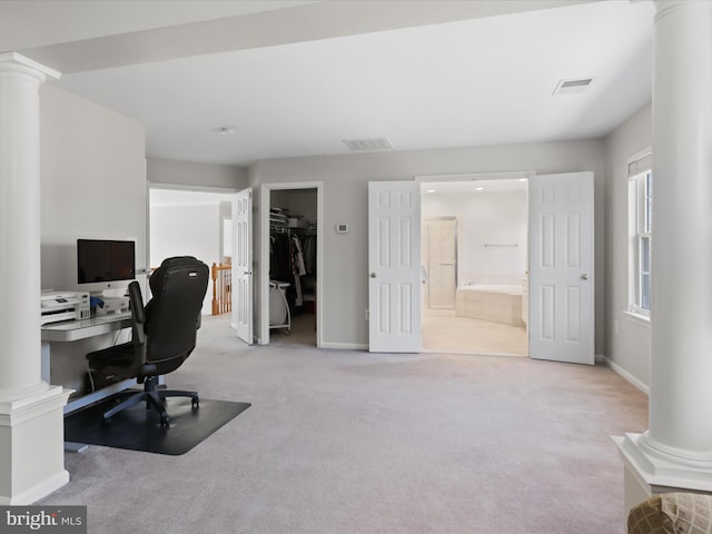 office area featuring decorative columns, visible vents, and carpet flooring