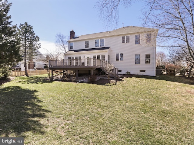 back of property with fence, a wooden deck, a yard, a chimney, and stairs