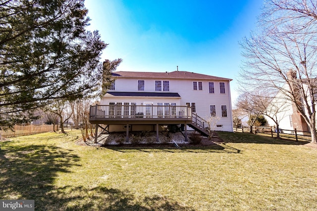 back of property with a wooden deck, a yard, and a fenced backyard