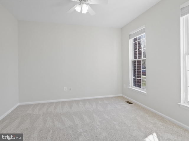 unfurnished room featuring carpet flooring, ceiling fan, baseboards, and visible vents