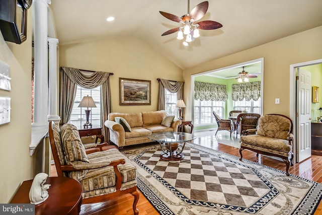 living room with ornate columns, ceiling fan, vaulted ceiling, and wood finished floors