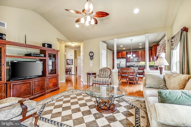 living room with lofted ceiling, decorative columns, light wood-style flooring, and ceiling fan with notable chandelier