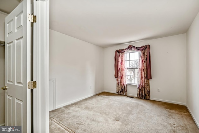 carpeted empty room with visible vents and baseboards