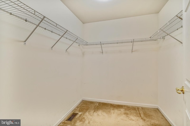 walk in closet featuring light carpet and visible vents