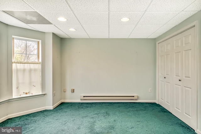 unfurnished bedroom featuring a baseboard heating unit, a closet, carpet flooring, and baseboards