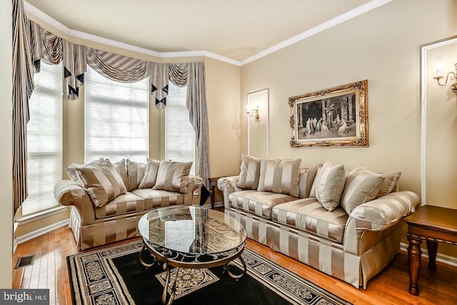 living room featuring ornamental molding, visible vents, and hardwood / wood-style floors