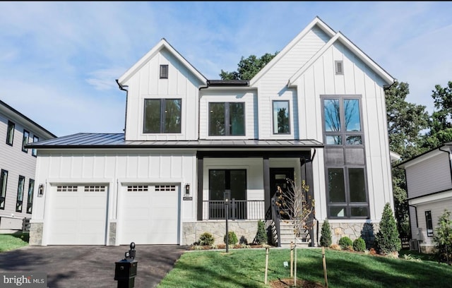 modern farmhouse style home with driveway, a standing seam roof, a porch, and board and batten siding