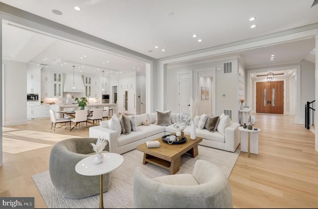 living area featuring recessed lighting, visible vents, and light wood finished floors