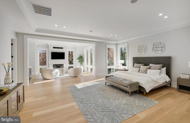 bedroom featuring recessed lighting, a fireplace, visible vents, light wood-type flooring, and crown molding