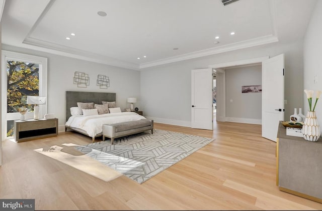 bedroom with recessed lighting, baseboards, ornamental molding, light wood-type flooring, and a tray ceiling