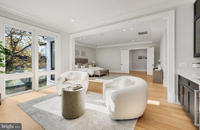 interior space featuring recessed lighting, visible vents, baseboards, ornamental molding, and light wood finished floors