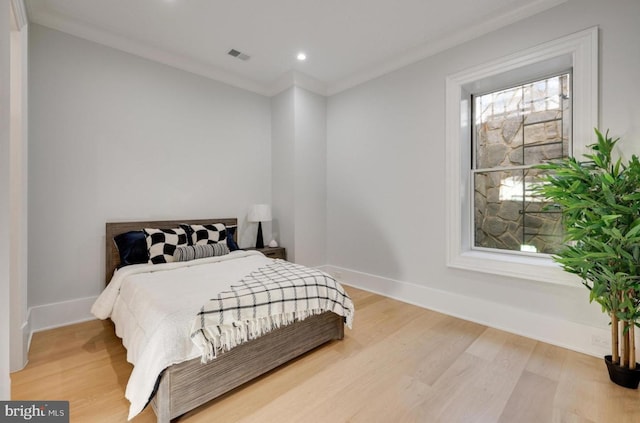 bedroom with visible vents, baseboards, crown molding, light wood-style floors, and recessed lighting