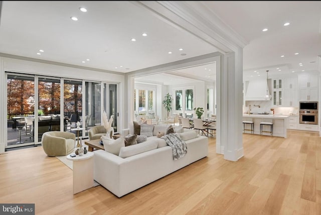 living area with light wood-type flooring and recessed lighting