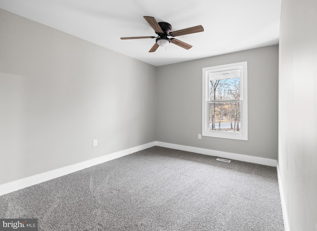 spare room with ceiling fan, carpet flooring, visible vents, and baseboards