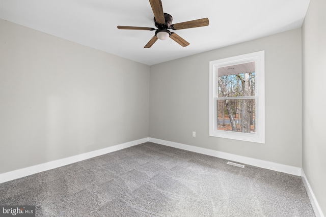 empty room with carpet, visible vents, ceiling fan, and baseboards