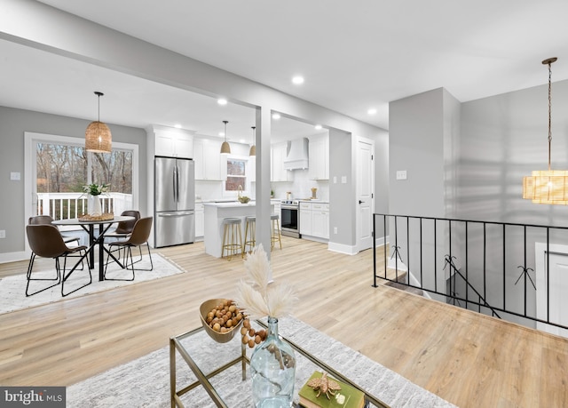 living area with light wood-style floors, baseboards, and recessed lighting