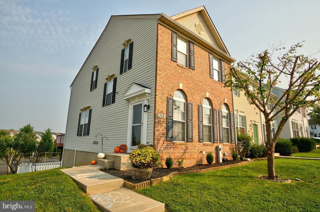 view of front of home with brick siding and a front yard