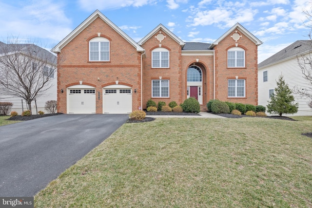 view of front of house with a front lawn, brick siding, driveway, and an attached garage