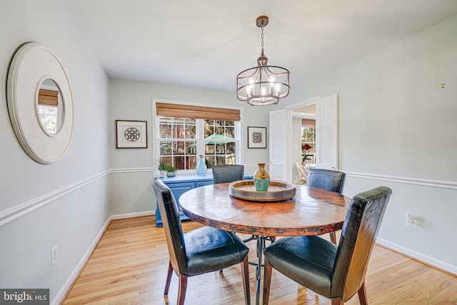 dining area with a notable chandelier, light wood-style flooring, and baseboards