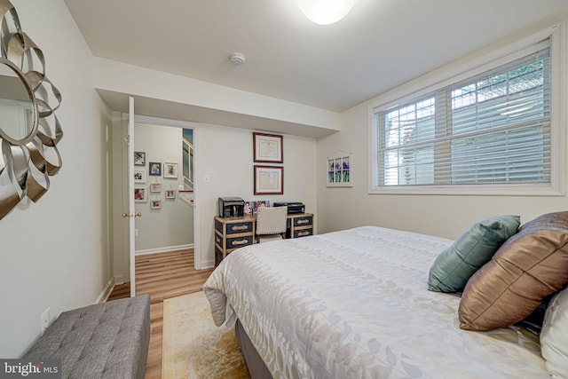 bedroom featuring baseboards and wood finished floors