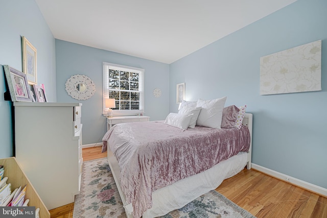 bedroom with baseboards and wood finished floors