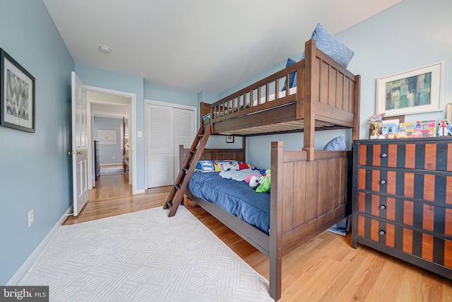 bedroom with a closet, baseboards, and wood finished floors