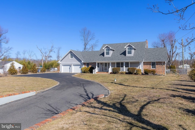 cape cod-style house with driveway, fence, a front yard, a garage, and brick siding