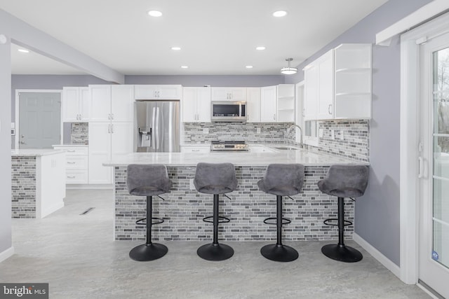 kitchen with open shelves, a sink, stainless steel appliances, a peninsula, and white cabinets