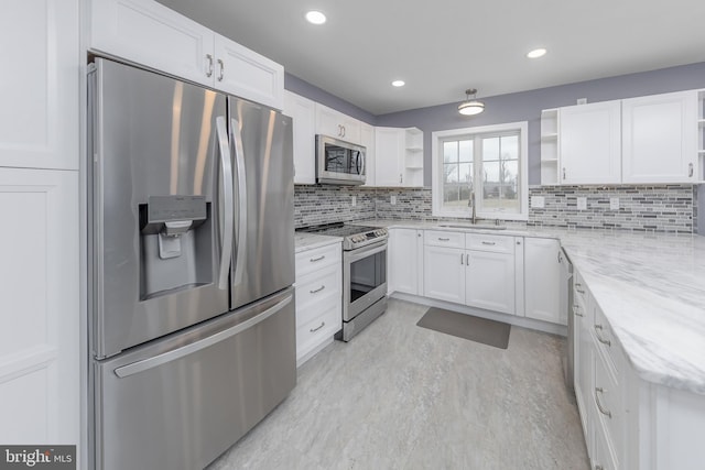 kitchen featuring a sink, white cabinetry, stainless steel appliances, and open shelves