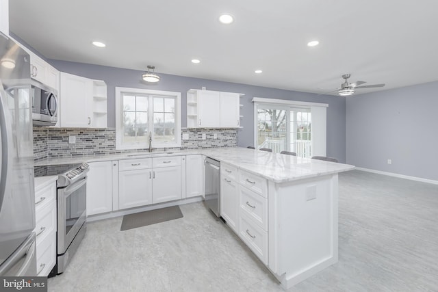 kitchen with open shelves, a sink, appliances with stainless steel finishes, a peninsula, and white cabinets