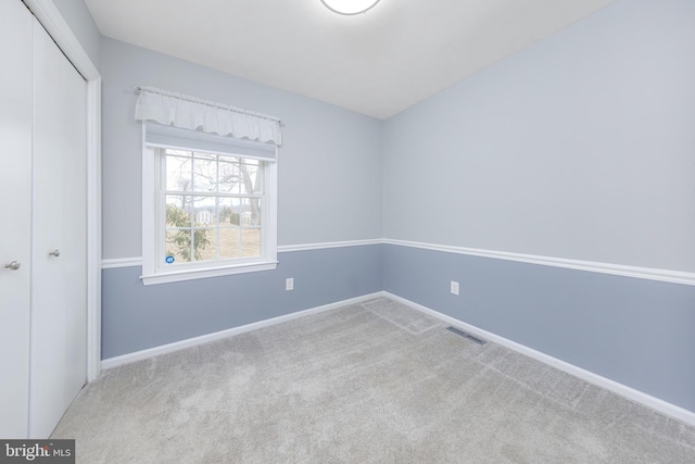 unfurnished bedroom featuring visible vents, baseboards, carpet, and a closet