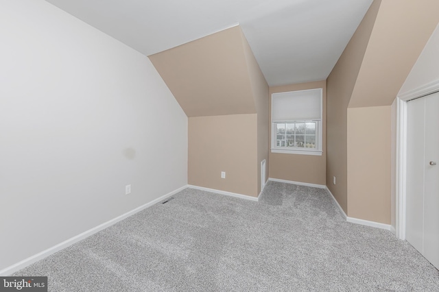 additional living space featuring lofted ceiling, carpet flooring, and baseboards