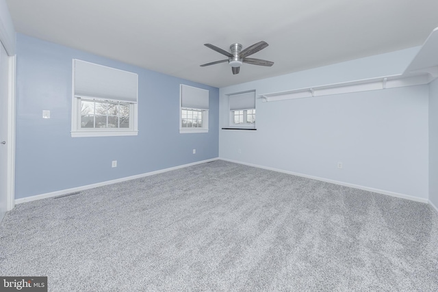 empty room with visible vents, a ceiling fan, baseboards, and carpet floors