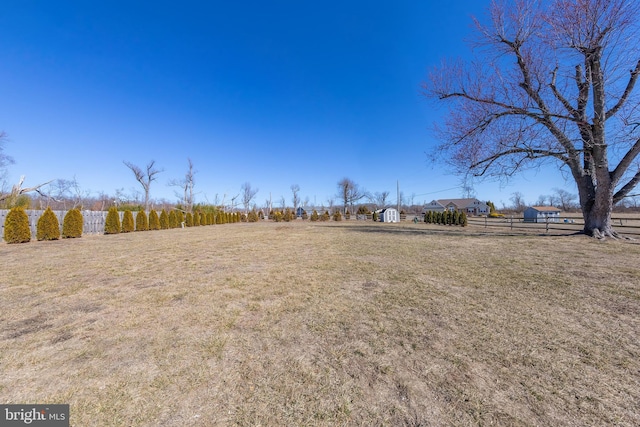 view of yard featuring a rural view and fence